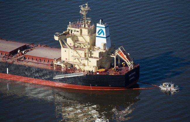 A spill response boat monitors a boom placed around the bulk carrier cargo ship Marathassa after a bunker fuel spill on Burrard Inlet in Vancouver, B.C., on Thursday April 9, 2015. THE CANADIAN PRESS/Darryl Dyck.