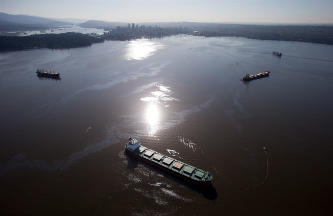Crews on spill response boats work to contain bunker fuel leaking from the bulk carrier cargo ship Marathassa, second right, on Burrard Inlet in Vancouver, B.C., on Thursday April 9, 2015. 