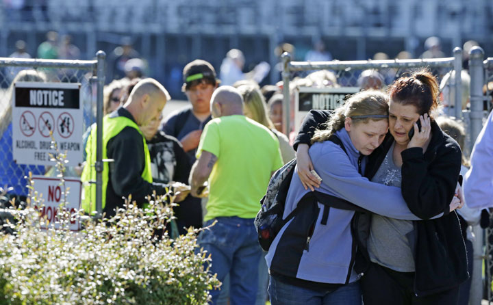 Parents and students walk away from an area at North Thurston High School Monday, April 27, 2015, where students were released to their parents after a shooting at the school earlier in the morning. Police say no one was injured, and school district officials say the gunman has been apprehended by staff.