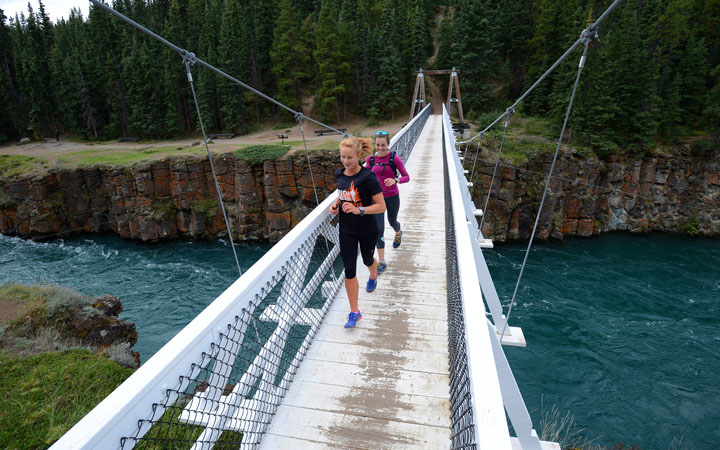 A couple of runners make their way across the Miles Canyon suspension bridge over the Yukon River in Whitehorse.