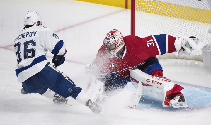 Tampa Bay Lightning's Nikita Kucherov slides in on Montreal Canadiens goaltender Carey Price during overtime of Game 1 NHL second round playoff hockey action in Montreal, Friday, May 1, 2015.