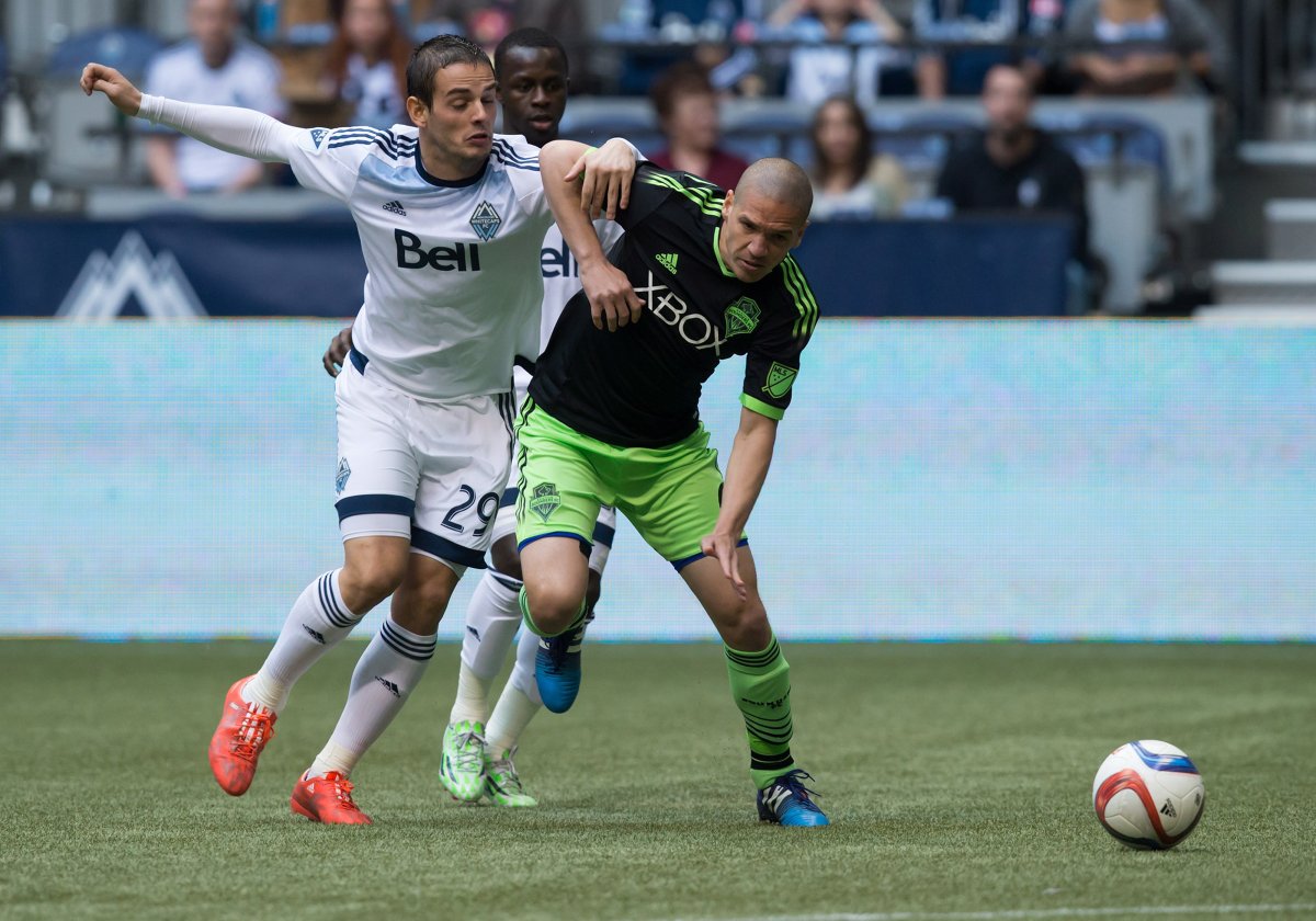 Vancouver Whitecaps' Octavio Rivero, left, of Uruguay, and Seattle Sounders' Osvaldo Alonso vie for the ball during the first half of an MLS soccer game in Vancouver, B.C., on Saturday May 16, 2015. 