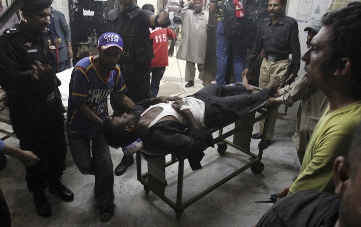 Pakistani rescue worker and police officers transport their colleague who was injured in a bomb blast at a local hospital in Karachi, Pakistan Sunday, May 24, 2015. Police say the son of Pakistan's president has escaped a roadside bomb attack unharmed after the blast killed three people and wounded 15. The attack happened late Sunday in Pakistan's restive Baluchistan province, long home to a low-intensity insurgency. (AP Photo/Fareed Khan).