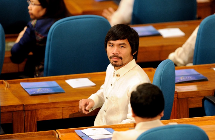 Congressman, Filipino eight-division world champion boxing hero Manny Pacquiao (C) sits with fellow lawmakers during the 15th congress at the House of Representatives in Quezon City suburban Manila on July 25, 2011.  