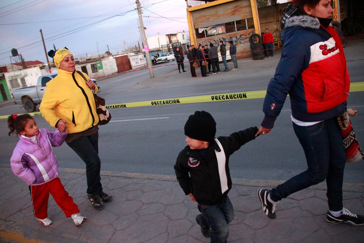 People pass through a crime scene in Chihuahua State, Mexico.