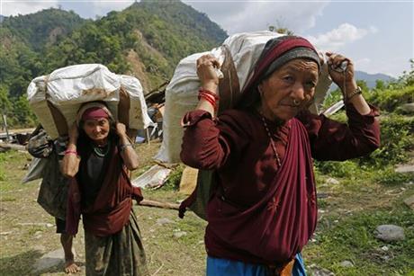 Elderly villagers start their 20km hike back up to their mountain home with international relief aid they received in the damaged village of Balua, near the epicenter of Saturday's massive earthquake, in the Gorkha District of Nepal, Thursday, April 30, 2015.