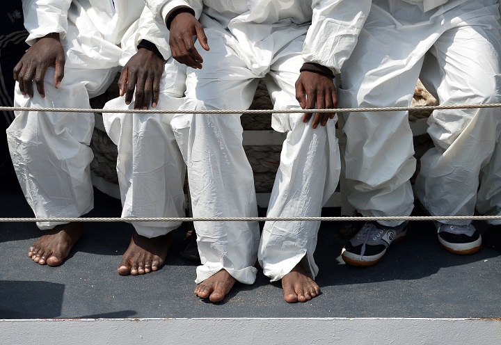 Rescued migrants wait before disembarking off the Italian Guardia Costiera vessel Fiorillo at the Sicilian harbour of Catania on April 24, 2015.
