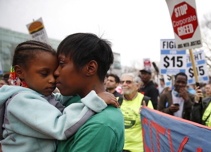 Latrese Williams of Dedham, Mass., snuggles with her daughter Desirae Shealey, 4, at a rally against income inequality in Boston on April 14, 2015.