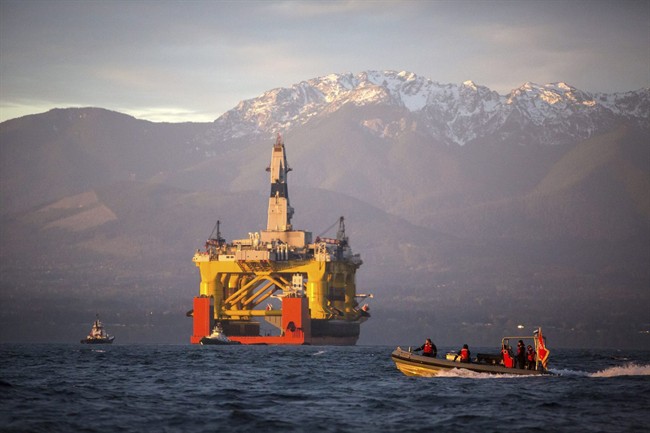 In this April 17, 2015 file photo, with the Olympic Mountains in the background, a small boat crosses in front of an oil drilling rig as it arrives in Port Angeles, Wash. 