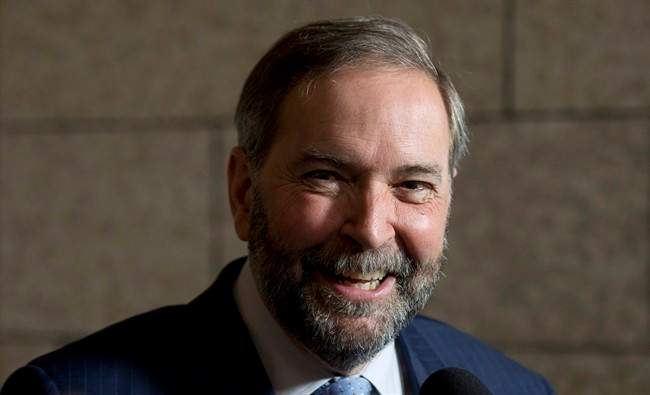 NDP leader Tom Mulcair smiles as he speaks with reporters following party caucus on Parliament Hill Wednesday, May 6, 2015 in Ottawa.