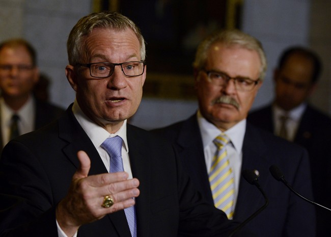 Agriculture Minister Gerry Ritz, right, looks on as International Trade Minister Ed Fast responds to questions about trade with the United States during a news conference on Parliament Hill in Ottawa, Tuesday, May 19, 2015. 