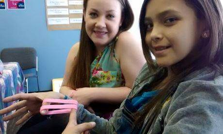 Allexis Siebrecht (right) and Samantha Lussier (left) hold the glow-in-the-dark bracelets that will be sold during the Bracelet Blitz fundraiser this weekend.