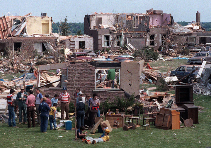 With torn houses all around them, neighbours, volunteers and friends take time out for lunch on June 2, 1985.
