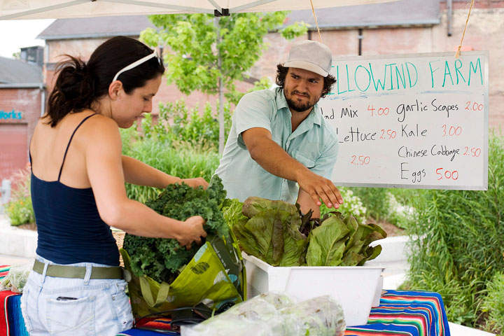 Dana Bondy picks up some fresh local vegetables from Uxbridge, Ontario farmer Travis Stocking as part of Community Supported Agriculture (CSA) at Evergreen Brick Works in Toronto on Tuesday, June 19, 2012.