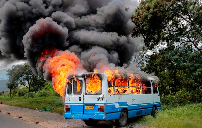 A bus burns after being set on fire by demonstrators in the Ngagara district of Bujumbura, Burundi Tuesday, May 12, 2015. A crowd who were marching to the funeral of a woman who died in recent protests were blocked from doing so by police, and the crowd then set fire to a bus and government car and motorcycle. 