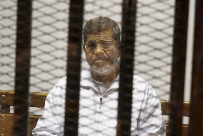 In this May 8, 2014 file photo, Egypt's ousted Islamist President Mohammed Morsi sits in a defendant cage in the Police Academy courthouse in Cairo, Egypt. 