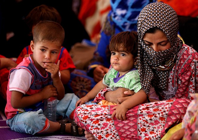 In this Sunday, April 19, 2015, file photo, a woman displaced from Ramadi settles in a mosque with children, in the al-Shurta neighbourhood in west Baghdad, Iraq. 