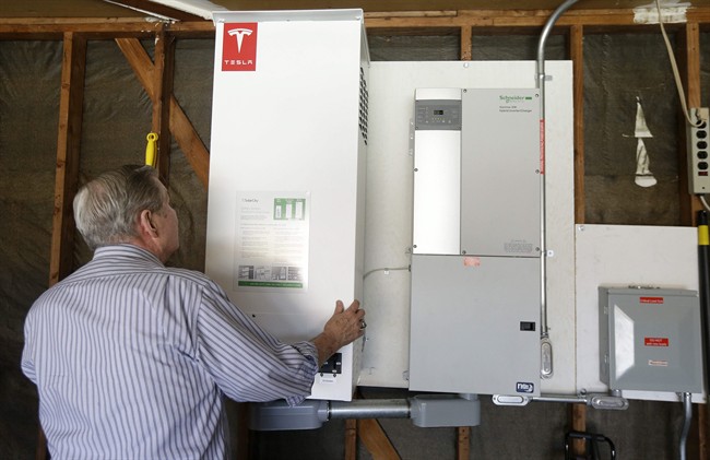 David Cunnigham shows a prototype Tesla battery system that powers his Foster City, Calif. home. 