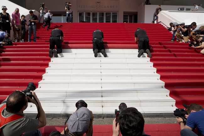 Members of the media surround workers laying down the red carpet on the steps of the Palais des Festivals ahead of the 68th international film festival, Cannes, southern France, Wednesday, May 13, 2015. The festival has elevated security measures for 2016.
