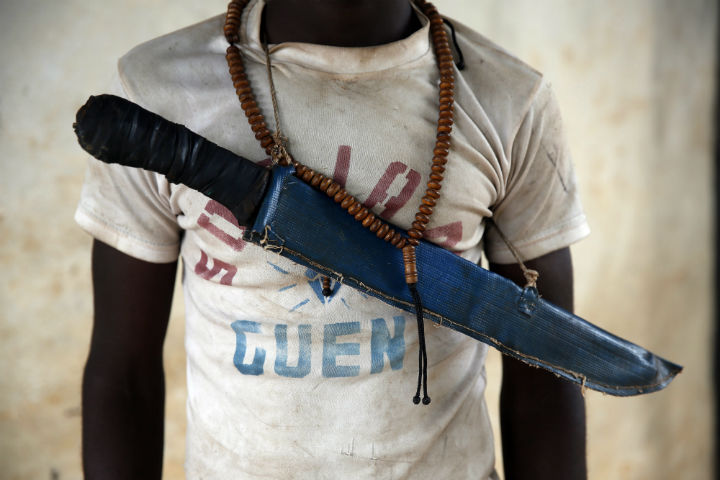 In this April 15, 2014 photo, an Anti-Balaka Christian fighter stands on the front of a looted Muslim store in Guen, some 250 kilometers north of Bangui, Central African Republic. 