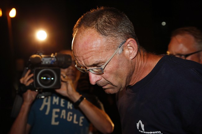 Douglas Garland is escorted into a Calgary police station in connection with the disappearance of Nathan O'Brien and his grandparents in Calgary, Alta., on July 14, 2014.