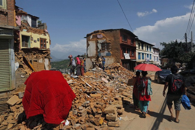 Nepalese people salvage belongings from the debris of their house damaged in last week earthquake in Chautara, Sindhupalchok district, Nepal, Saturday, May 2, 2015.