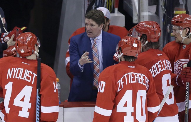 Detroit Red Wings head coach Mike Babcock, center, talks to his team during the third period of an NHL hockey game against the Winnipeg Jets in Detroit on Feb. 14, 2015.