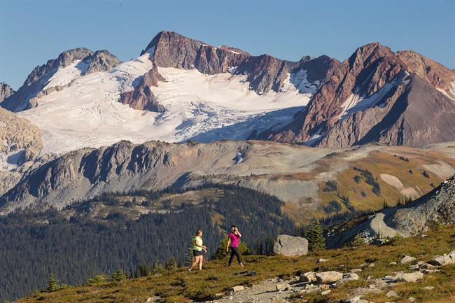 Two day hikers in the Whistler Mountain alpine with Fitzsimmons, Overloard and Fissile mountains behind are shown in a handout photo.