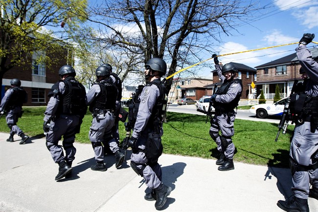 A police tactical team searches a side street after receiving a call that there were gunshots fired in Toronto in this file photo on Tuesday, April 13, 2010. The call was a hoax, and such calls are often referred to as "swatting.".