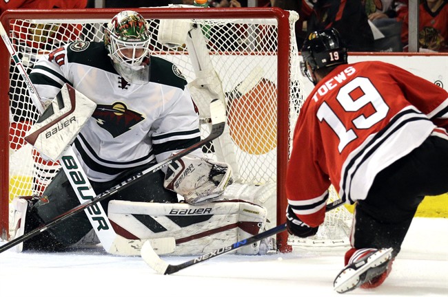 Minnesota Wild goalie Devan Dubnyk, left, fails to stop a shot and goal by Chicago Blackhawks center Jonathan Toews, right, during the second period of Game 2 in the second round of the NHL Stanley Cup hockey playoffs in Chicago, Sunday, May 3, 2015.
