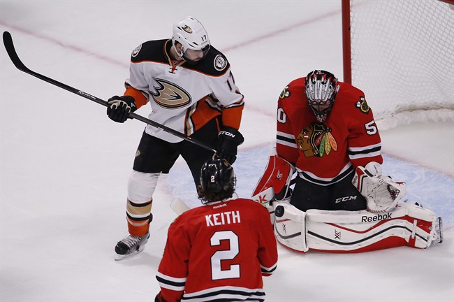 Chicago Blackhawks goalie Corey Crawford (50) stops a shot as Anaheim Ducks center Ryan Kesler (17) looks on during the first period in Game 6 of the Western Conference finals of the NHL hockey Stanley Cup playoffs, Wednesday, May 27, 2015, in Chicago. (.