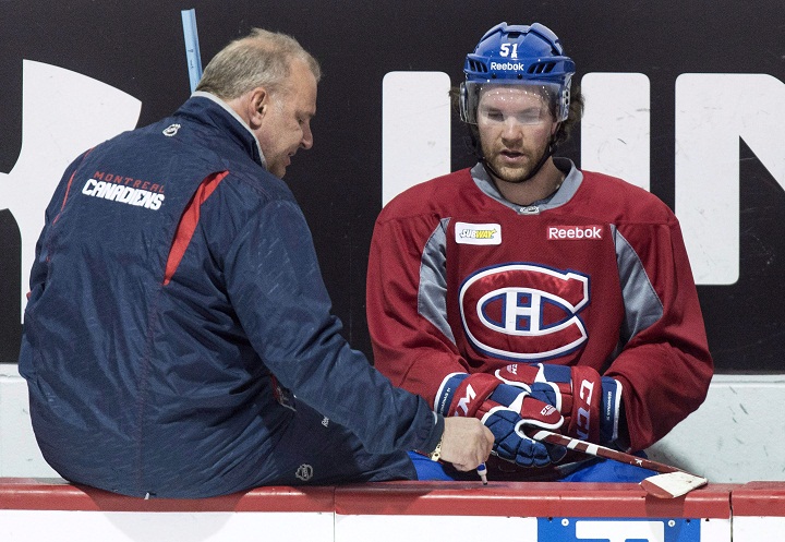 Montreal Canadiens head coach Michel Therrien, left, gives a few pointers to David Desharnais during a practice Monday, April 13, 2015 in Brossard, Que. Desharnais is feeling better and says he's ready to play in Game 3 in Pampa Wednesday night.