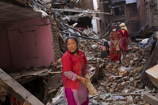 Nepalese women remove debris searching their belongings from their house that was destroyed a week ago during the earthquake in Bhaktapur, Nepal, Sunday, May 3, 2015. 