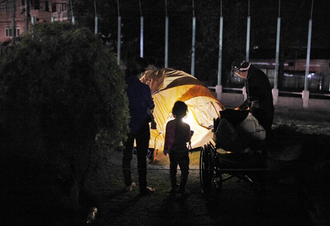 A family sets up a tent to rest for the night in an open space in Kathmandu, Nepal, Tuesday, May 12, 2015.