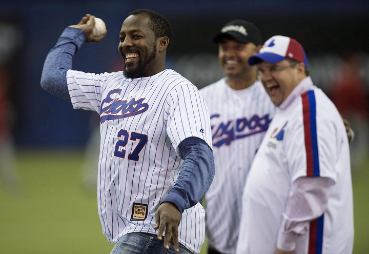 Former Montreal Expos Vladimir Guerrero throws a ceremonial pitch next to Montreal mayor Denis Coderre and former teammate Orlando Cabrerra during a pre-game ceremony as the Toronto Blue Jays face the Cincinnati Reds in MLB exhibition play Friday, April 3, 2015 in Montreal. 