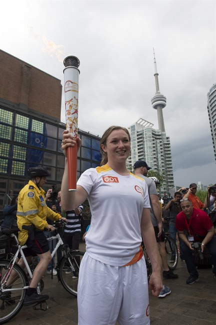 Trampoline gymnast Rosannagh "Rosie" MacLennan carries the first Toronto 2015 Pan Am Games torch in Toronto on Saturday, May 30, 2015.