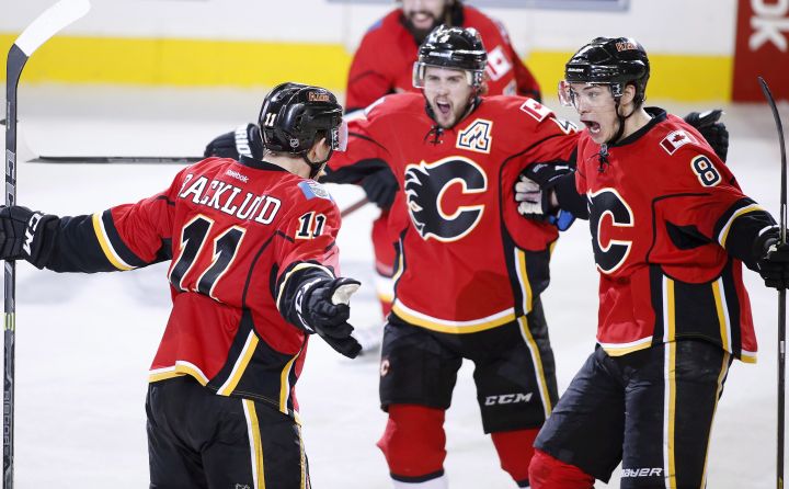 Calgary Flames' Mikael Backlund, left, from Sweden, celebrates his winning overtime goal against the Anaheim Ducks with Kris Russell, middle, and Joe Colborne during overtime NHL playoff action in Calgary on May 5, 2015. 
