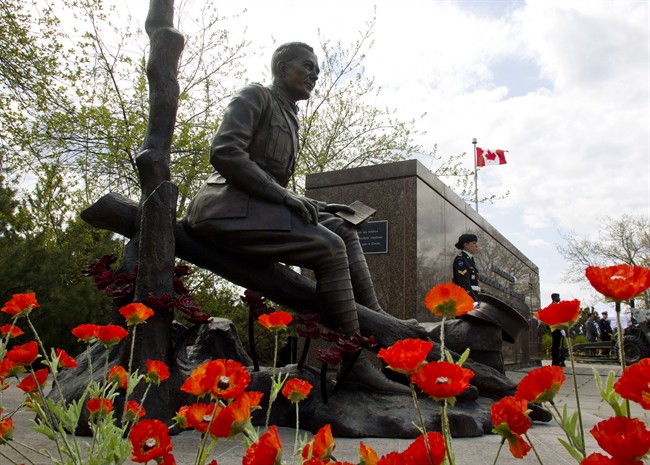 Poppies surround the newly unveiled statue of Lt.-Col. John McCrae to commemorate the Second Battle of Ypres and his poem 'In Flanders Fields,' during a ceremony in Ottawa on Sunday, May 3, 2015. THE CANADIAN PRESS/Fred Chartrand.