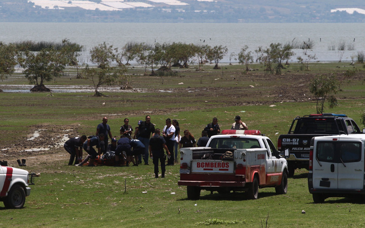 Firefighters carry the body of one of the two Canadians who were still missing out of the waters of Lake Chapala, in Chapala, Jalisco State, Mexico, on May 21, 2015. 