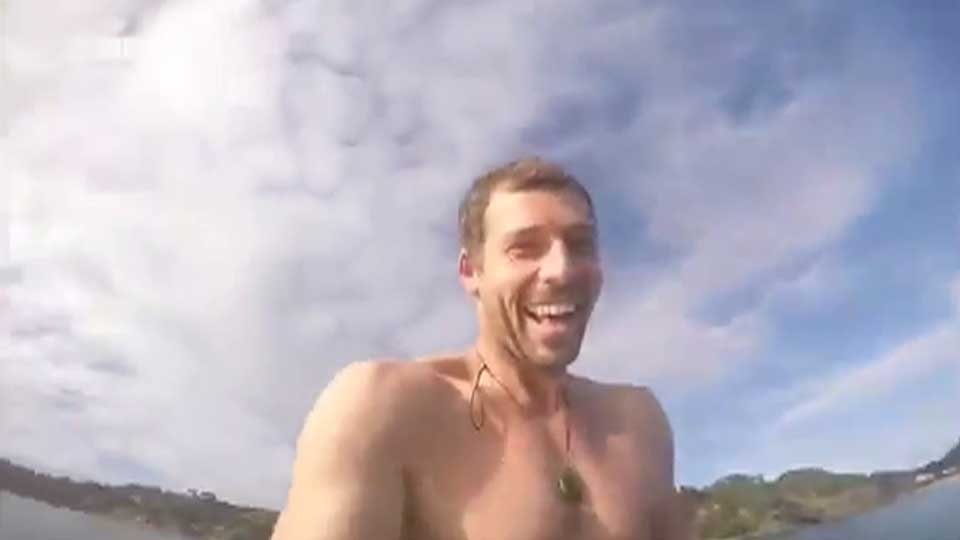 Orca whale nibbles on man's paddle board