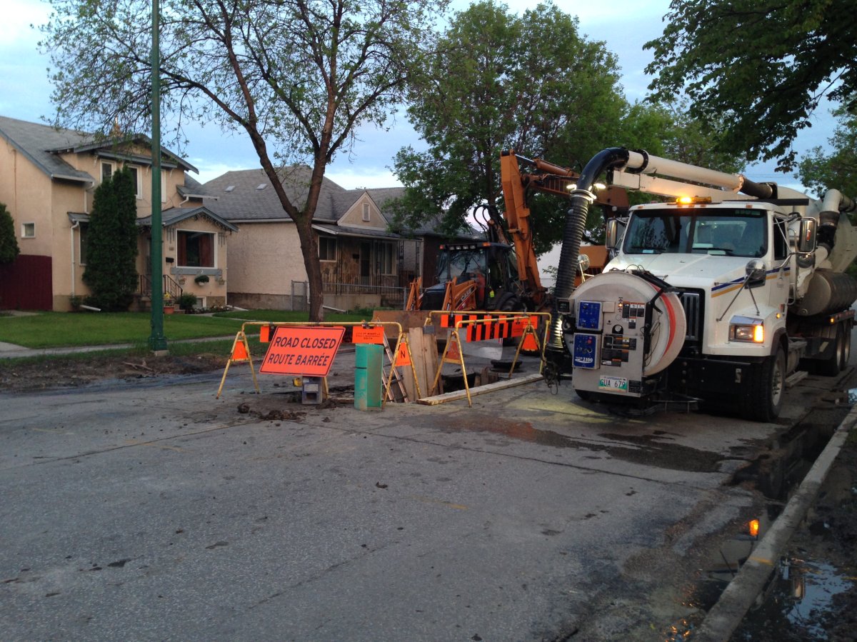 Crews work on a sinkhole on Arlington St. between Ellice Ave. and Sargent Ave.