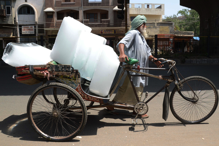 An Indian worker used a ricksahw to transport ice from an ice factory in Amritsar on May 27, 2015, as the country endured a heatwave which claimed more than 2,000 lives.