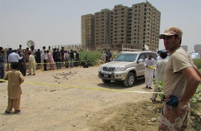 Police cordon off the site of an attack by gunmen in Karachi, Pakistan, Wednesday, May 13, 2015. The attackers killed dozens of people on Wednesday aboard a bus in southern Pakistan bound for a Shiite community center, in the latest incident targeting the religious minority, police said. (AP Photo/Shakil Adil).