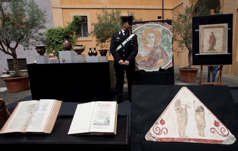 A Carabinieri Italian paramilitary police officer stands next to ancient artifacts returned to Italy by The United States, on display in a Rome Carabinieri barracks, Tuesday, May 26, 2015.