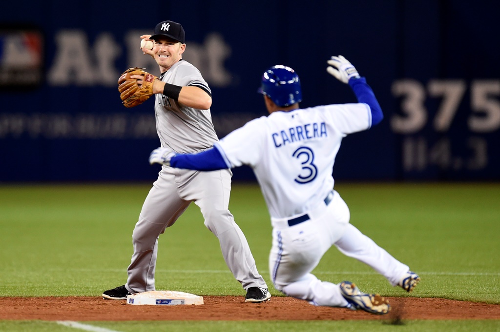 New York Yankees' Stephen Drew throws to first after Toronto Blue Jays' Ezequiel Carrera is forced out at second on a fielder's choice.