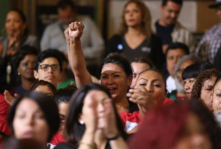 Workers react as the Los Angeles City Council votes to raise the minimum wage in the city to $15 an hour by 2020, making it the largest city in the nation to do so, in Los Angeles Tuesday, May 19, 2015. 