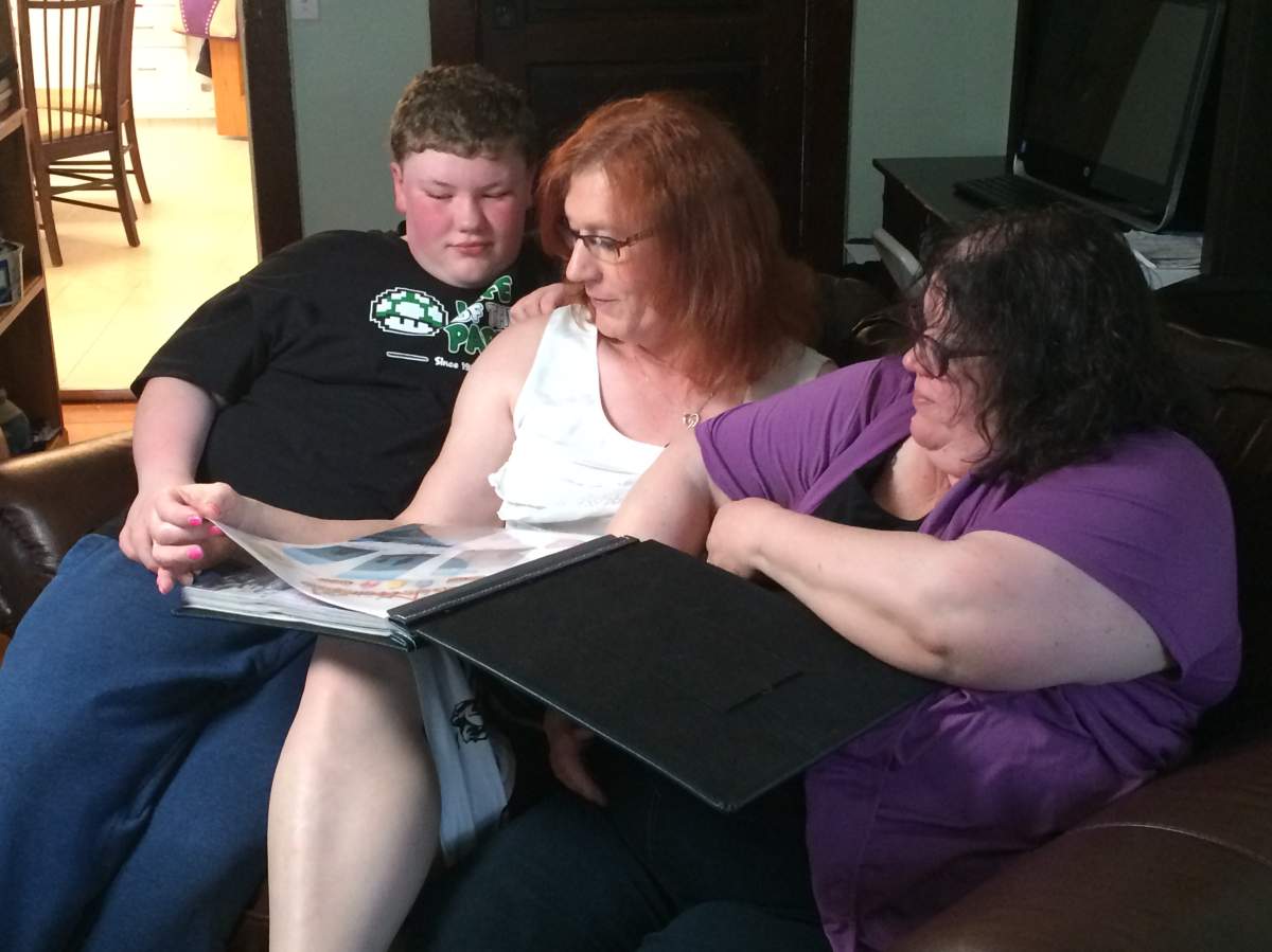 The Budd family looks over a scrapbook from the last family vacation they took before Brice started going by Laura.