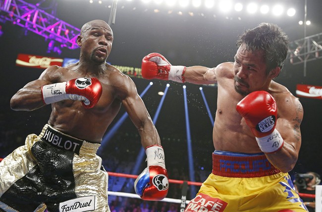 Manny Pacquiao, from the Philippines, right, throws a right against Floyd Mayweather Jr., during their welterweight title fight on Saturday, May 2, 2015 in Las Vegas.