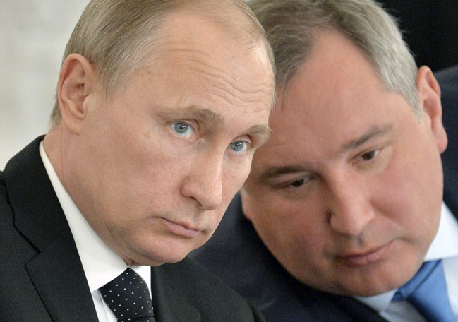In this March 17, 2015 file photo, Russian President Vladimir Putin, left, and Deputy Prime Minister Dmitry Rogozin attend a meeting of the Victory Day celebrations organizing committee in the Kremlin in Moscow.