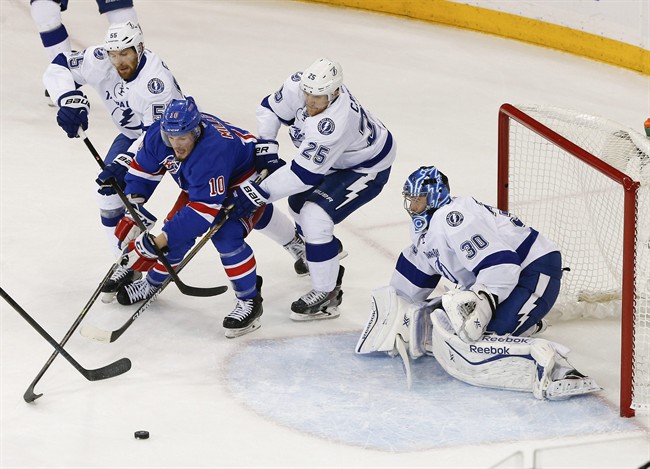 New York Rangers center J.T. Miller (10) is double teamed by Tampa Bay Lightning defenseman Braydon Coburn (55) and defenseman Matt Carle (25) as he tries to score on Tampa Bay Lightning goalie Ben Bishop (30) during the first period of Game 5 of the Eastern Conference final during the NHL hockey Stanley Cup playoffs, Sunday, May 24, 2015, in New York. (AP Photo/Kathy Willens).
